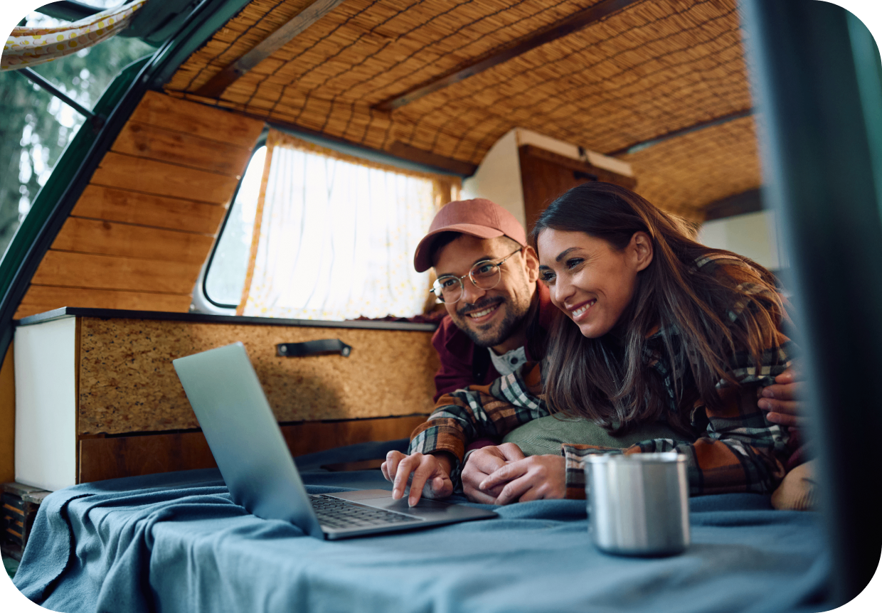 GettyImages-1791194070 Couple using laptop inside a camper van.