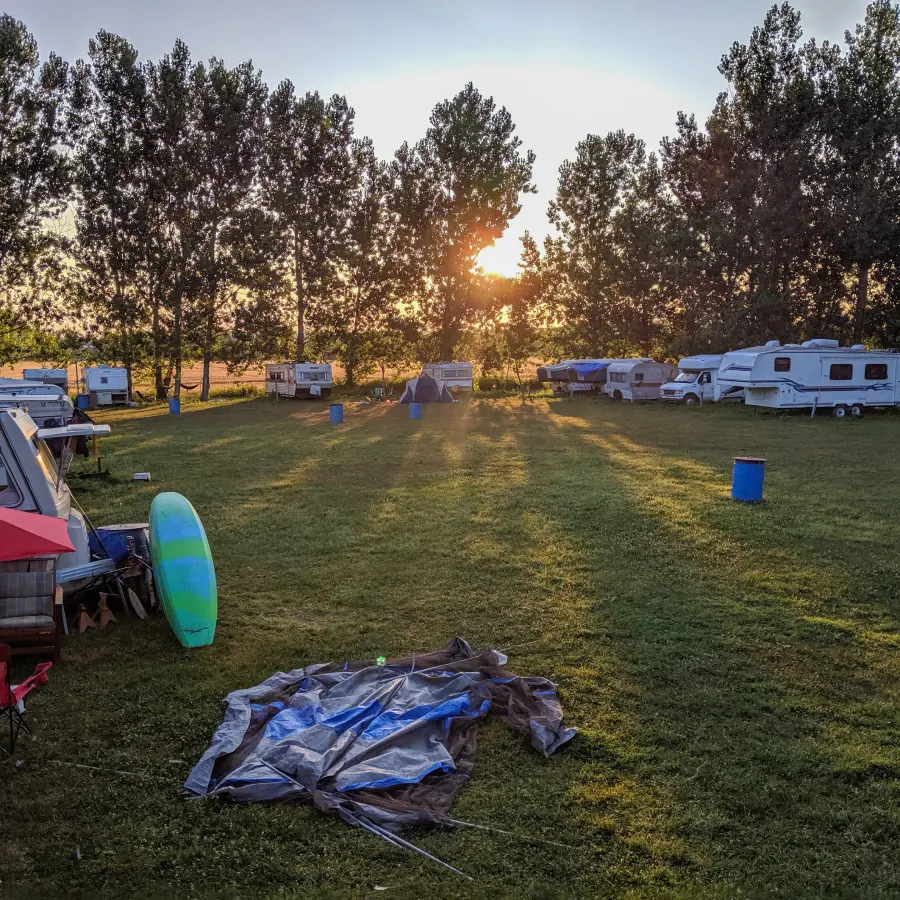 GettyImages-2158619561 Sunset over campsite with trees and trailers.