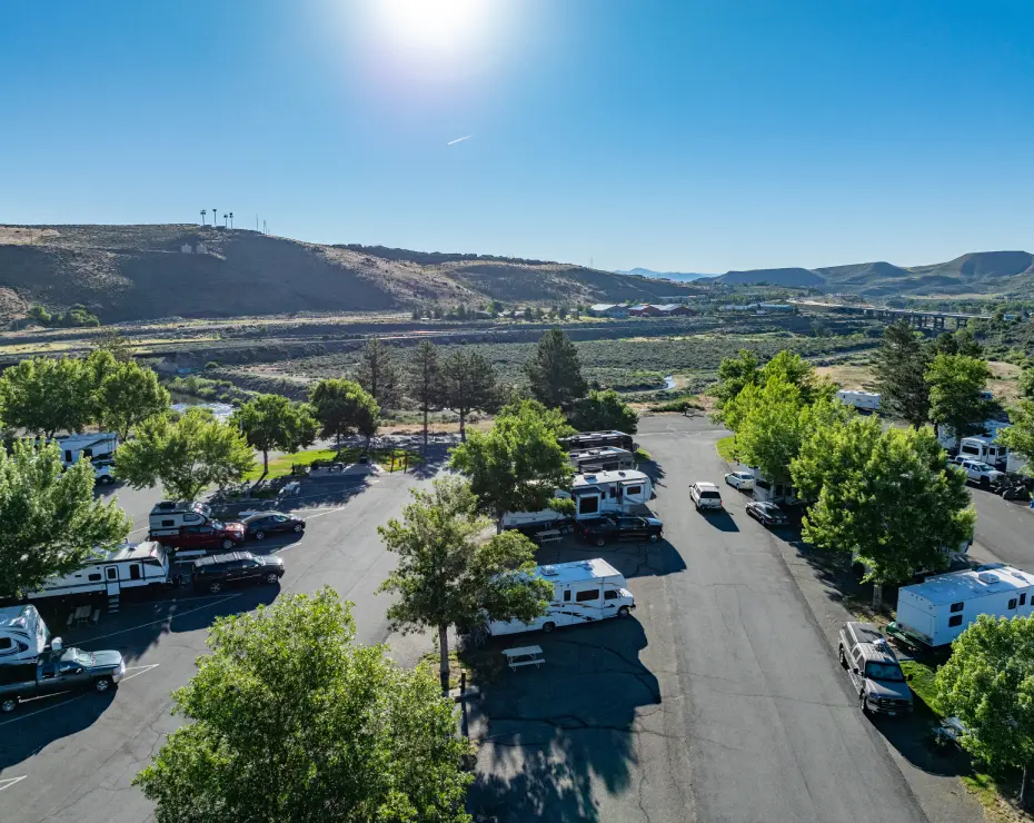 GettyImages-lots RV park with trees and mountain view.