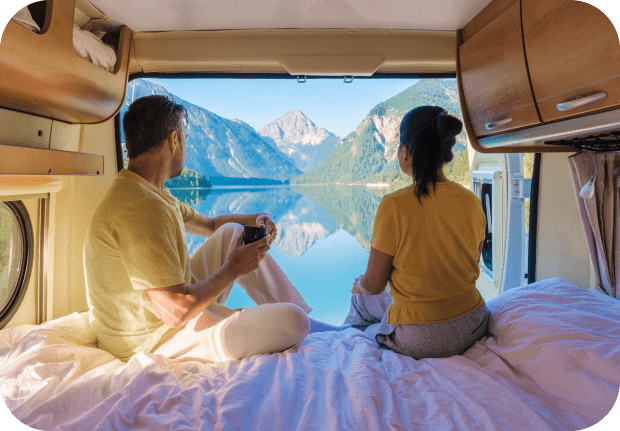 GettyImages-2189111496 Couple enjoys mountain view from camper van.