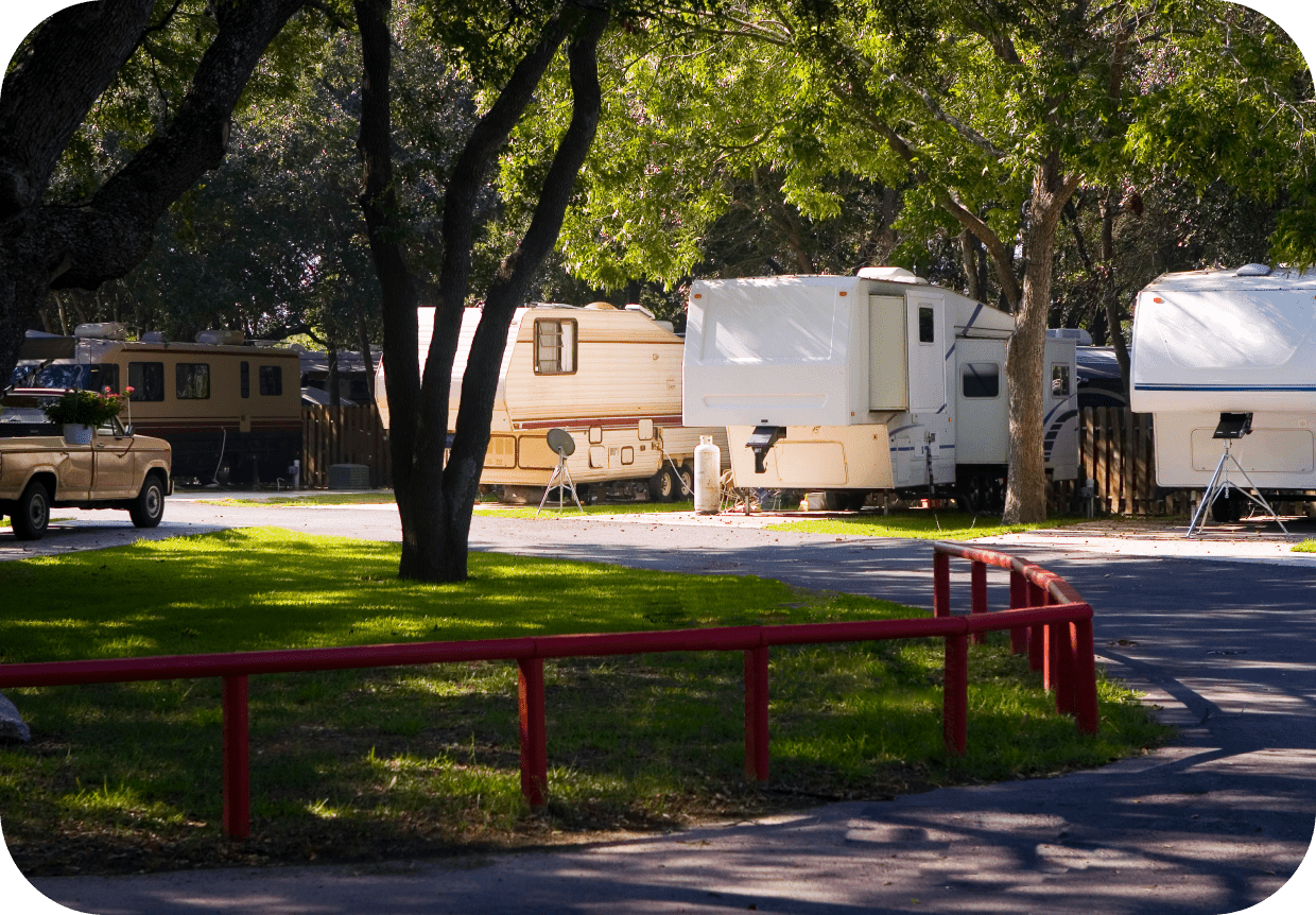 GettyImages-471013547 RVs parked under trees in a campground.